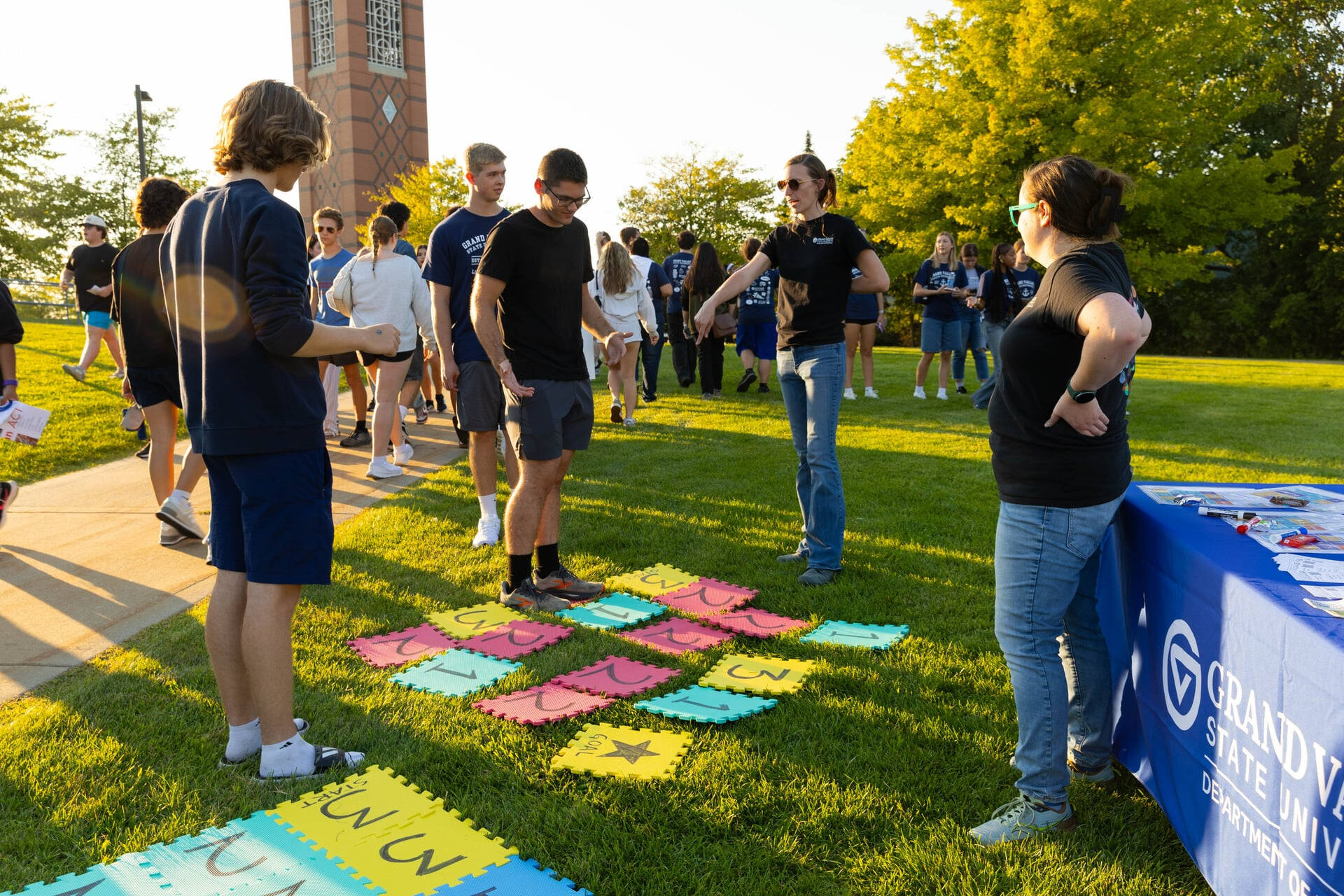 colorful squares on ground for game, math faculty standing to give directions